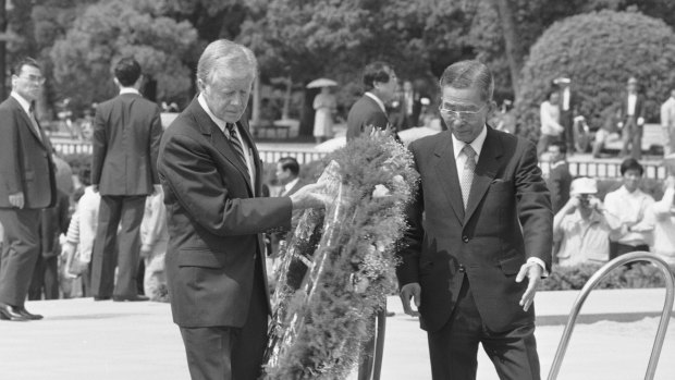 In 1984, guided by then-Hiroshima mayor Takeshi Araki, former president Jimmy Carter places a wreath at the memorial cenotaph, a monument containing the names of the dead in the 1945 atomic bombing of Hiroshima.