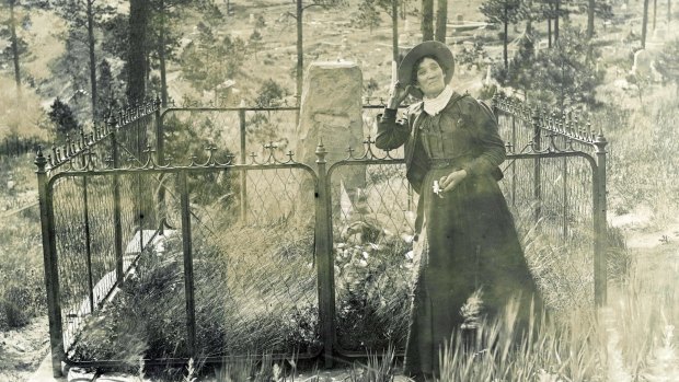 Martha Jane Burke, popularly known as Calamity Jane, standing by the grave of Wild Bill Hickok in Mount Moriah Cemetery, Deadwood, South Dakota.