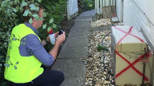 An asbestos taskforce staff member securing a property.