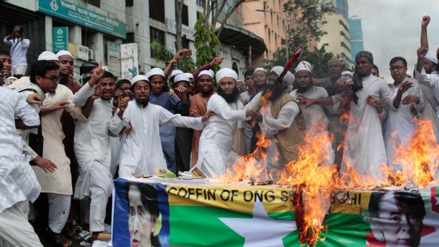 Bangladeshi activists from various Islamic groups burn a Myanmar flag and mock coffin during a protest in Bangladesh, against the persecution of Rohingya Muslims.