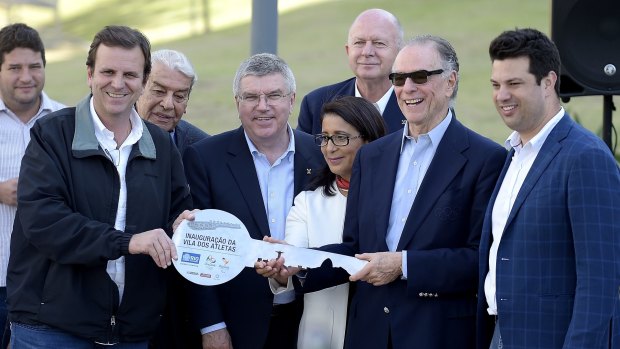 From left, Rio de Janeiro's Major Eduardo Paes delivers the key to the Olympic Village to Organising Committee president Carlos Arthur Nuzman on Wednesday.