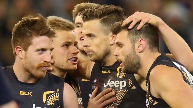 Challenge: Richmond players huddle after a goal against Hawthorn in round 18.