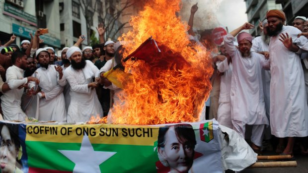 Bangladeshi activists burn the national flag of Myanmar during a protest rally against the persecution of Rohingya Muslims in Myanmar.