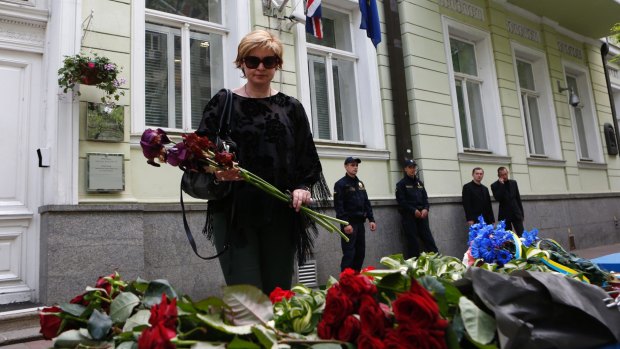 A woman lays flowers in front of the British Embassy in Kiev, Ukraine.