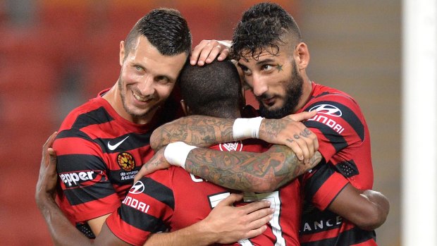 Happy days are here again: Western Sydney's Romeo Castelen celebrates with teammates after scoring against the Roar.