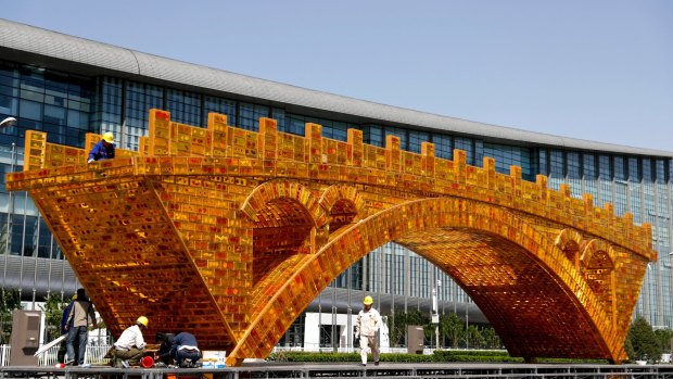 Workers install a 'Golden Bridge of Silk Road' structure outside the venue  for China's Belt and Road Forum for International Cooperation in Beijing in April.
