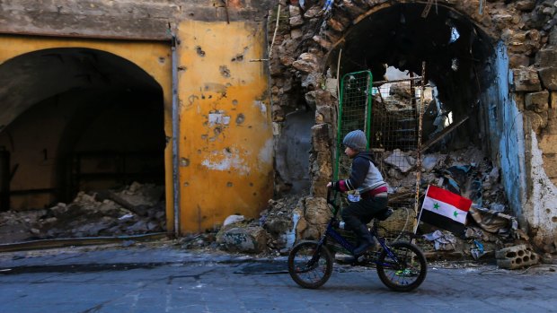 A boy rides his bike in the Jalloum neighbourhood of eastern Aleppo.