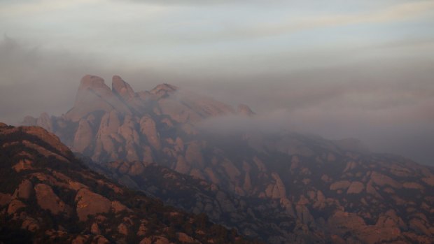 Smoke of a wildfire over El Montserrat mountain in El Bruc, Spain