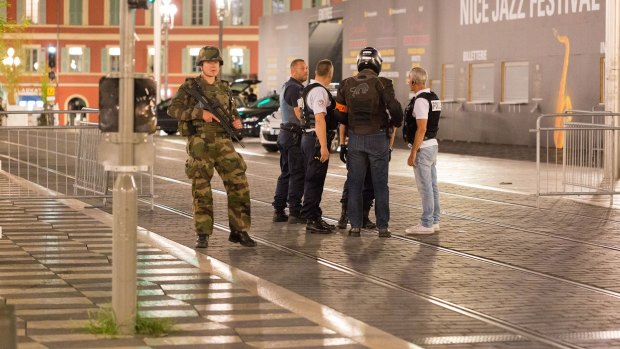 Police officers and a soldier stand by the sealed off area of the attack.