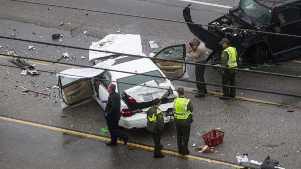 Los Angeles County Sheriff's deputies investigate the scene of a car crash involving Bruce Jenner.