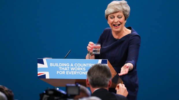 Philip Hammond, British chancellor of the exchequer, hands Prime Minister Theresa May a cough sweet as she delivers her speech at the party's annual conference in Manchester last year.