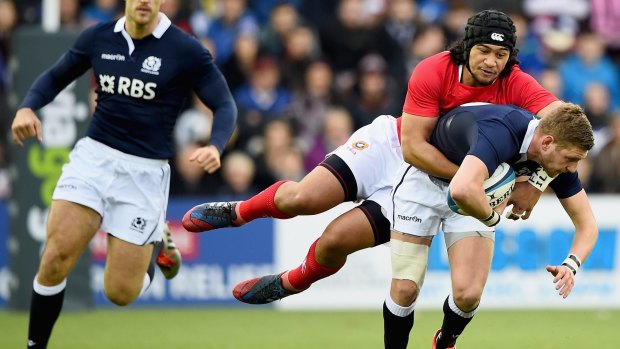 Finn Russell of Scotland is tackled by Latiume Fosita of Tonga.
