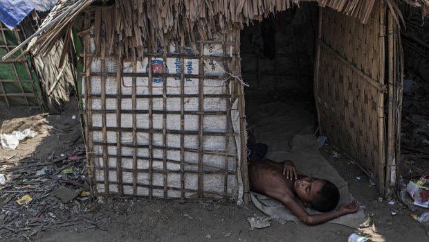 A Rohingya boy naps in his family's temporary shelter next to an internal displacement camp in Myanmar.
