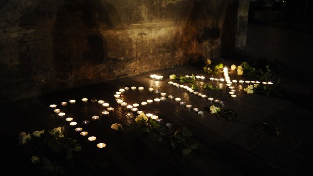 Lit candles forming the word "peace" in French are layed outside the Capitole building in Toulouse, southern France.