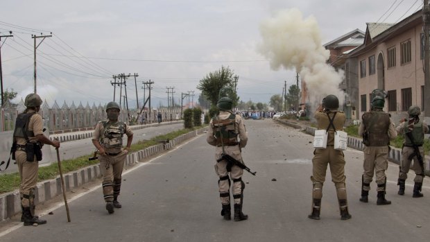 An Indian paramilitary solider fires tear gas shells at Kashmiri Muslims during a protest near Eidgah in Srinagar, Indian controlled Kashmir.