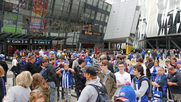 Football fans arrive at the AFL's first Good Friday game. 