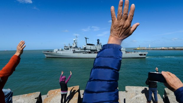 People wave to the Argentine destroyer Sarandi as it leaves a navy base in Mar del Plata, Argentina, to participate in the search of the missing submarine. 