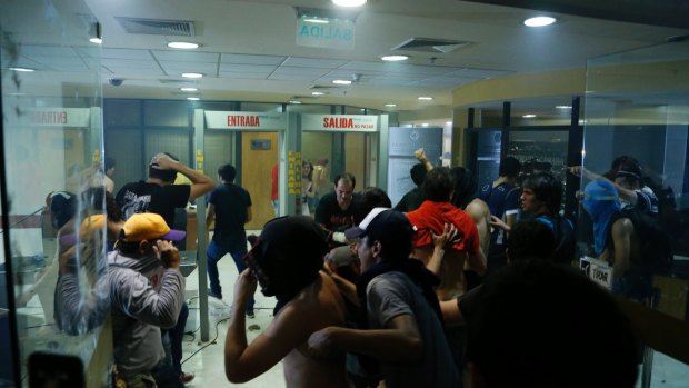 People enter to the Congress building after breaking through police lines.