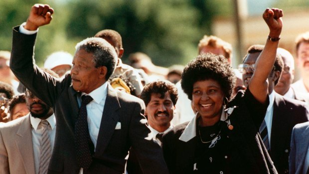Nelson and Winne Mandela walk together, raising clenched fists, upon his release from Victor prison, Cape Town, after 27 years in detention in 1990.