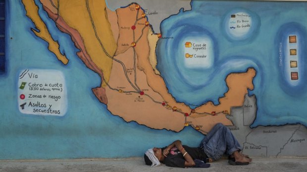 A young undocumented migrant rests under a map of routes for migrants through Mexico at the La 72 shelter in Tenosique, Mexico last year. 