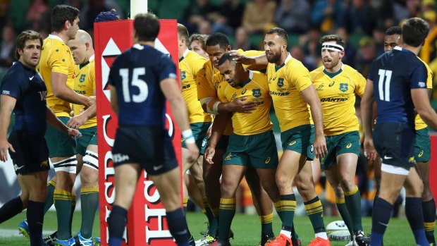Finding form at last: Will Genia and the Wallabies celebrate a try in Perth as Australia recorded their best win of the year.