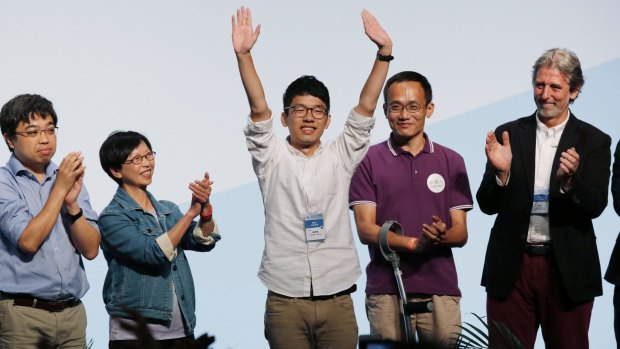 Student Nathan Law, center, who helped lead the 2014 protests, celebrates after winning a seat at the legislative council elections in Hong Kong.