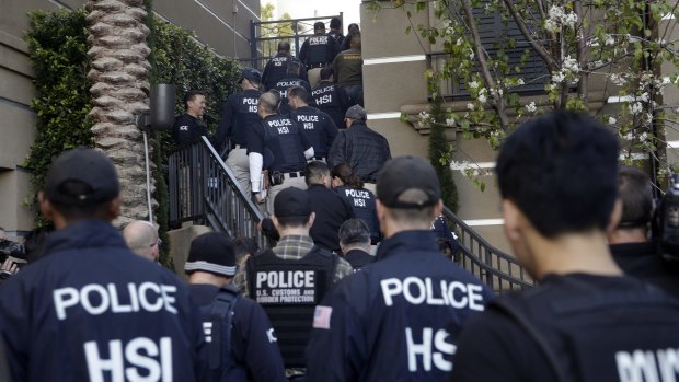 Federal agents raid the apartment complex in Orange County, California, where authorities say a birth tourism business charging pregnant women $US50,000 for lodging, food and transportation was operating. 