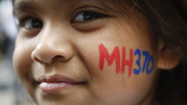 A Malaysian child has her face painted with MH370 during a remembrance event to mark the second anniversary of the jet's disappearance.