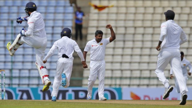 Captain's fall: Sri Lankan bowler Rangana Herath, second right, and wicketkeeper Dinesh Chandimal, far left, celebrate the dismissal of Australia's Steve Smith.