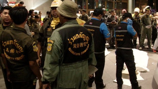 Rescue workers stand by the covered victims of an accident at Siam Commercial Bank's headquarters in Bangkok, Thailand. 