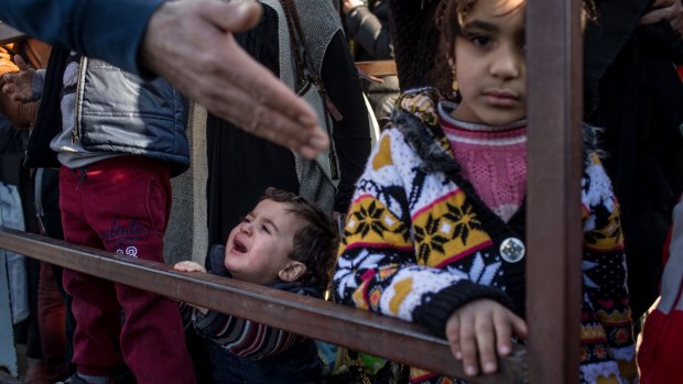 Syrian refugees wait to cross the border into Turkey.