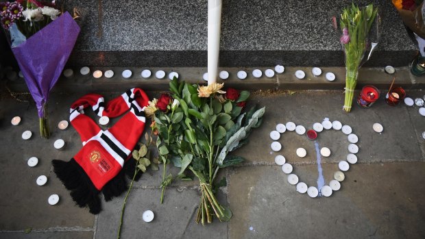 A United scarf, laid in the shape of a heart, lies next to flowers at a candlelit vigil to honour the victims of Tuesday's terror attack in Manchester.