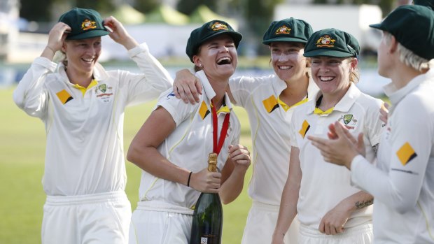 Australian players celebrate winning the Test with team mates.
