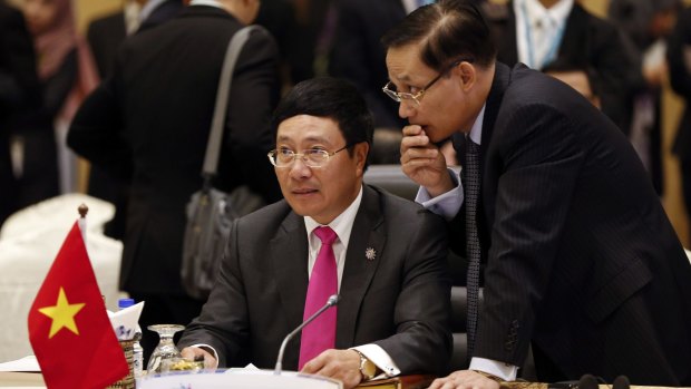 Vietnam's Foreign Minister Pham Binh Minh, left, listens to his delegation member during the Association of Southeast Asian Nations foreign ministers meeting plenary session in Kuala Lumpur.