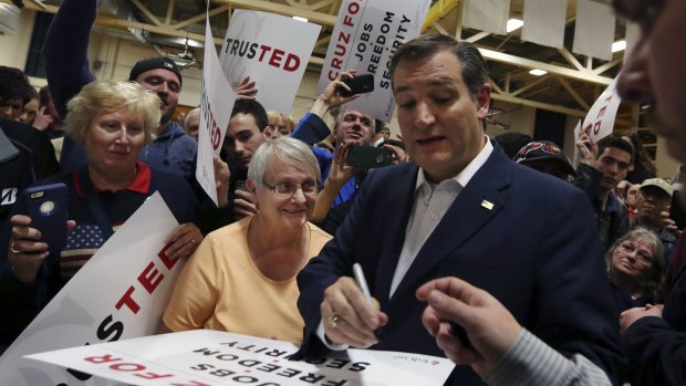 Ted Cruz signs posters for his supporters at a campaign rally on Friday.
