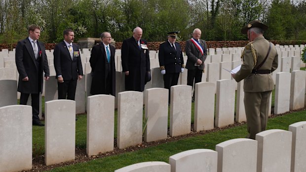 Governor-General Sir Peter Cosgrove, centre, at the tombstone of the unknown soldier.