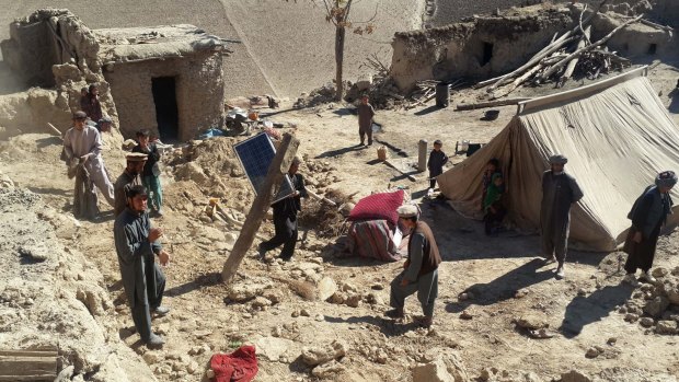 Afghan men carry their belongings in quake-hit Takhar province, north-east of Kabul, Afghanistan. Rescuers were struggling to reach quake-stricken regions in Pakistan and Afghanistan on Tuesday.