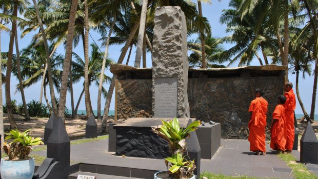 Trio's tribute: Monks visit the memorial to Sri Lanka's worst rail disaster.