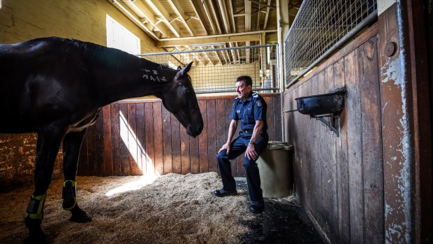 Leading Senior Constable Kevin Knowles with Tango at the 104-year-old Police Mounted Branch stables in Southbank, which is about to be vacated by Victoria Police. 