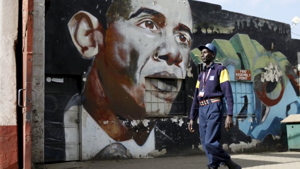 A security guard walks past a wall mural depicting US President Barack Obama  in  Nairobi.