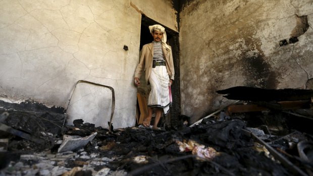 A man stands in a room of a house burnt after an air strike by the Saudi-led coalition struck a missile base in Sanaa on Thursday.  