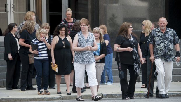 Victims and their families walk across the street from the federal courthouse after testimony was heard in the sentencing hearing of cancer doctor Farid Fata, Monday, July 6, 2015 in Detroit. (David Guralnick/Detroit News via AP)