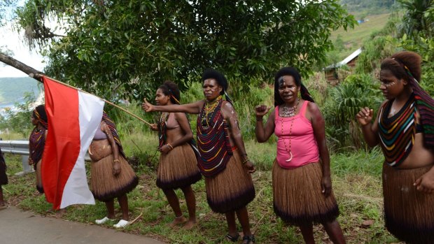 Papuan women wave the Indonesian flag during the visit of Indonesian President Joko Widodo. 