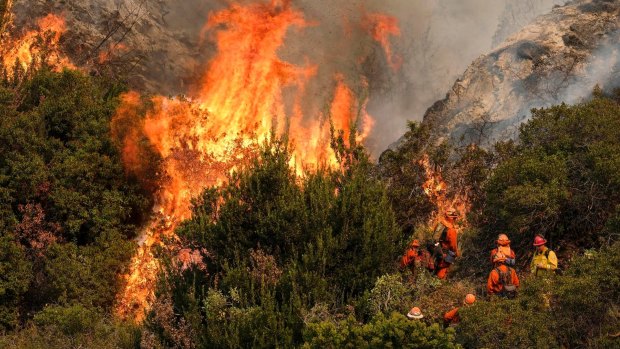 A crew with Cal Fire battles a brushfire on the hillside in Burbank, California, on Saturday. 