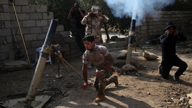 Iraqi army soldiers fire mortars at Islamic State militants east of Mosul.
