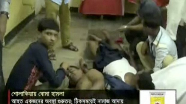 Injured people are assisted after an attack in Kishoreganj, Bangladesh.