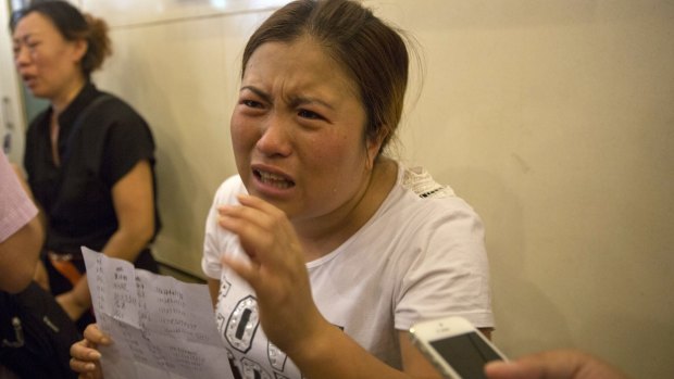 Wang Baoxia talks to a journalist about her missing brother Wang Quan outside a government press conference in Tianjin on Saturday.