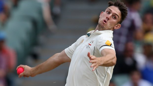 Pinkish hue: Mitchell Marsh sends one down during the first day-night Test.