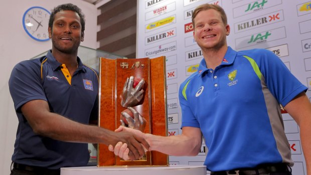Sri Lankan cricket captain Angelo Mathews and Australian cricket captain Steven Smith pose in front of Warne-Murali trophy.