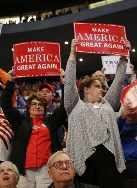 Attendees hold "Make America Great Again" signs during a campaign event for Donald Trump.
